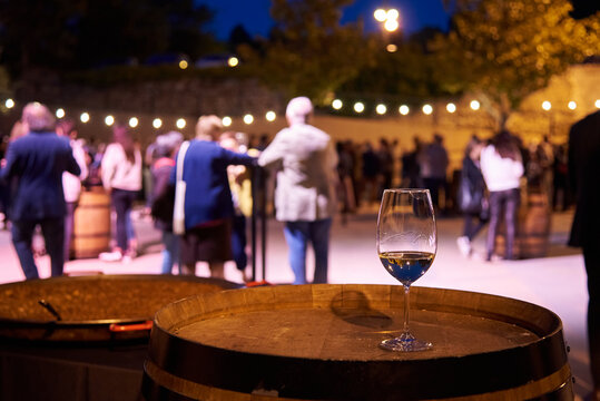 imagen de una copa de vine blanco con un fodo de un evento