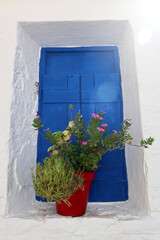 Vacation destination Chios Greece: typical Greek blue wooden doors and shutters on white wall in Volissos in the north of the Aegean island. Attractive place to be, with few tourists so far.