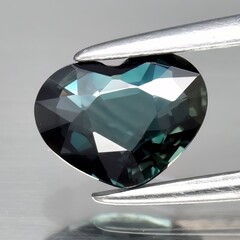Natural gemstone green sapphire on gray background