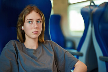 Fototapeta na wymiar Teenage girl with earphones travelling inside the train.