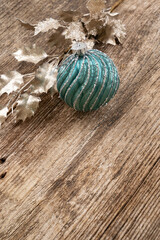 Fototapeta na wymiar Christmas teal decorations with golden holly leaf over aged wooden background