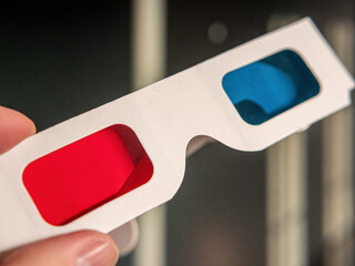 A 3D glasses with red/blue foil in hand