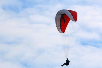Paraglider flying in a blue sky