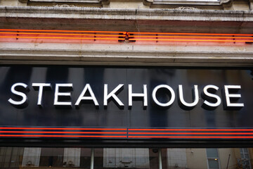 steakhouse sign on exterior of restaurant. Food eatery in city 
