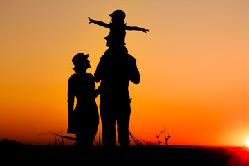 A Happy family by the sea at sunset in travel silhouette in nature
