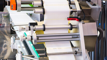 Fragment of the conveyor of sticking labeling machine. Abstract industrial background.