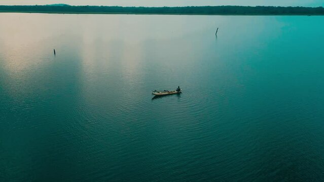 Cinematic aerial drone view a traditional wooden fishing boat sailing on a beautiful large lake