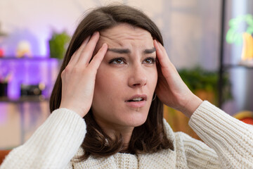 Displeased young woman rubbing temples to cure headache problem, suffering from tension and...