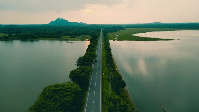 Drone aerial view of a road built mid of a huge lake moving forward