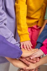 cropped close up shot of children hands putting on each other. friendship. kids putting their hands...
