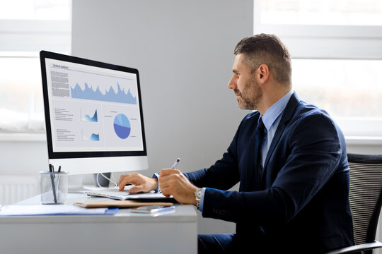 Man Financial Analyst Thinking On Statistical Information Comparing Data In Charts Graphs, Sitting In Office