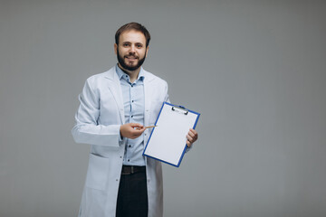 Medical Internship. Portrait Of Happy Male Doctor Student In Uniform Holding Clipboard In Hands And...