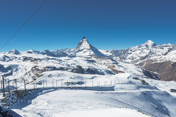 Fototapeta na wymiar Matterhorn peak in Zermatt with a beautiful ski slopes all around it. Ski resort in Switzerland.