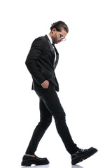 businessman walking with hands in pockets and looking down