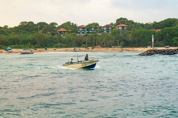 Fototapeta na wymiar Fishing boat with fishermen in the ocean. Photography for tourism background, design and advertising. 10 January 2023, Sooriya hotel spa, Sri Lanka