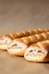 Sausage rolls cooked on brown greaseproof baking paper. Traditional British food concept.
