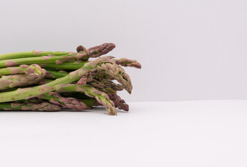 Selective focus of fresh asparagus spears on isolated white background.