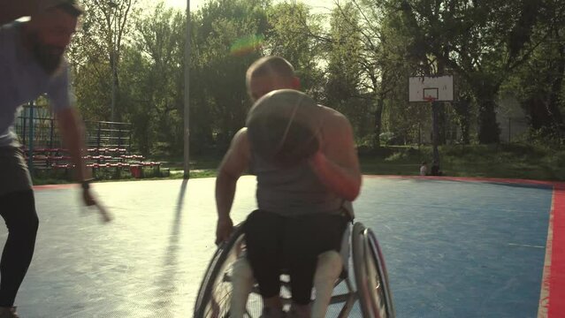 A physically challenged person play street basketball with his friends.	
