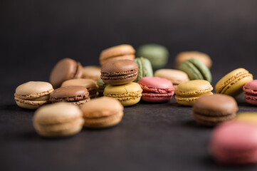 Sweet colorful macarons dessert on a black background
