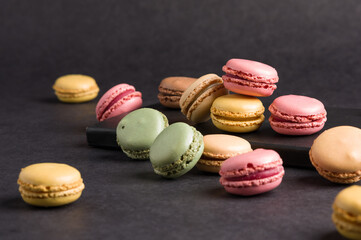 Sweet colorful macarons dessert on a black background