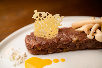 selective focus on cheese grid decorating meat appetizer in a plate. Close-up