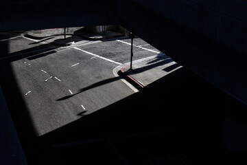 Between light and shadow, we see a street that is located under a bridge and is considered like a...