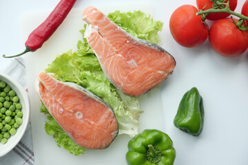 Raw, fresh salmon steak and vegetables on white 