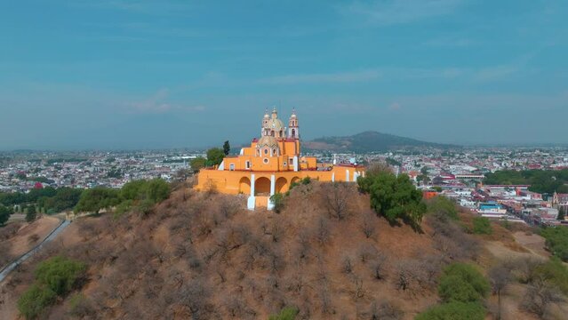 Tilt down Gran pir&aacute;mide de Cholula con ciudad de fondo