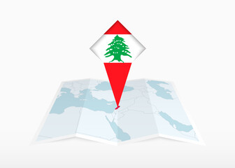 Obraz premium Lebanon is depicted on a folded paper map and pinned location marker with flag of Lebanon.