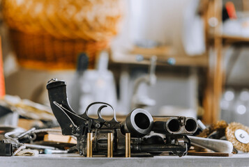 Retro weapons, rifle, revolver with cartridges, barrels, parts and accessories, ammunition lie on...