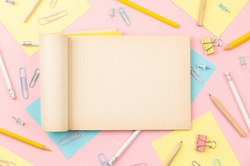 Exercise book on background of stationery items for girls or women on light pink background. Back to school. Female Student's, pupil's or engineer's supplies. Office objects on pastel pink background - 585548001