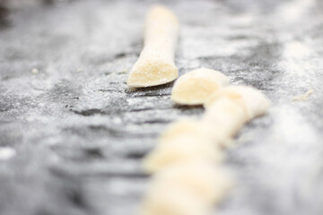 gnocchi with flour being prepared to be baked. dough to make gnocchi. preparing italian meal. gnocchi with selective focus.