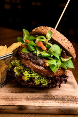 close-up of tasty double hamburger with fresh green lettuce and spinach