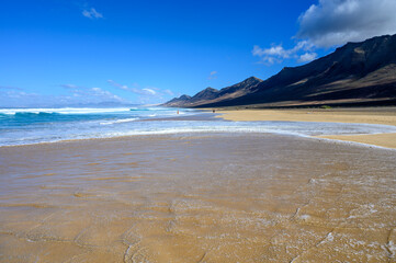 View on difficult to access golden sandy Cofete beach hidden behind mountain range on Fuerteventura, Canary islands, Spain