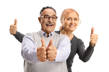 Happy mature woman behind a cheerful man gesturing thumbs up