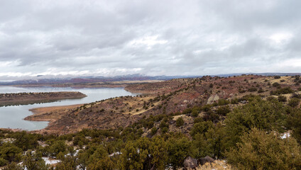 Water reservoir in red rock basin with overcast skie in rural New Mexico - 585552688