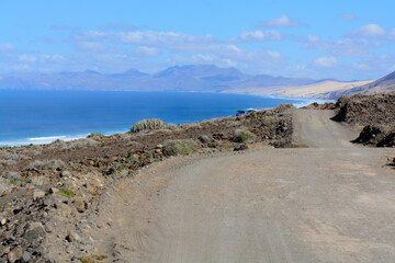 Fototapeta na wymiar View on difficult to access golden sandy Cofete beach hidden behind mountain range on Fuerteventura, Canary islands, Spain