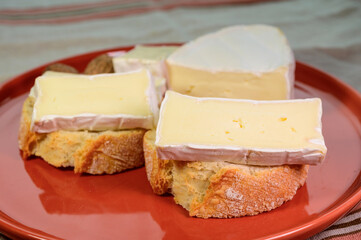 Lunch with fresh baguette and French white mold soft cow milk cheese Caprice des Dieux from Haute-Marne region, France