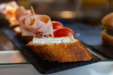 Typical mini burger snack of Basque Country, pinchos or pinxtos, small piece of bread with different toppings, served in bar in San-Sebastian, Spain