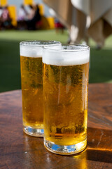 Fresh draught lager or IPA beer is glass served in outdoor cafe close up, pint of beer close up