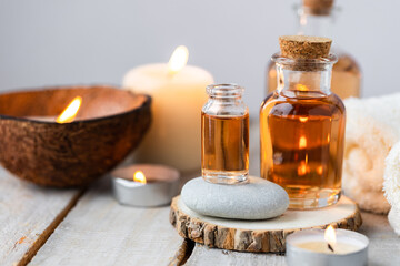 Concept of spa treatment in salon with pure organic natural oil. Atmosphere of relax, detention. Aromatherapy, candles, towel, wooden background. Skin care, body gentle treatment