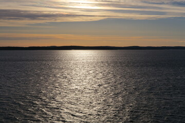 Die Abendsonne scheint auf die Wellen des Oslofjords bei Rygge in Norwegen - obrazy, fototapety, plakaty