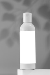 Empty bottle with a cosmetic product with a place for a logo on a pedestal. Micellar water, facial cleansing lotion.