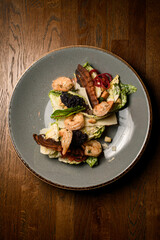 top view on plate with shrimps and roasted bacon in salad