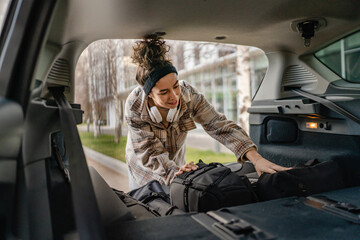 one young woman pack luggage baggage suitcase in the trunk of the car