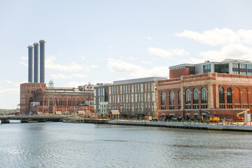 Naklejka premium An abandoned old brick manufacturing factory building stands tall with broken windows and overgrown vegetation, showcasing the industrial heritage of a bygone era