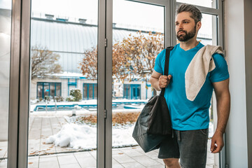 Bearded young sportsman walking in a corridor