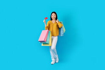 Fototapeta premium Pretty chinese woman enjoying easy shopping with bank card