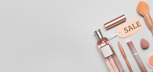 Set of makeup cosmetics and accessories for sale on light background with space for text