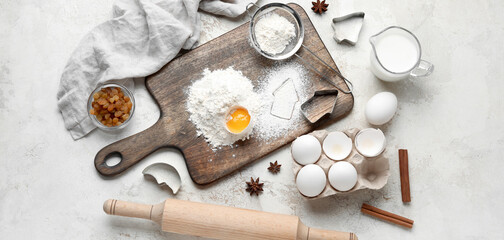 Different ingredients and utensils for baking cookies on light background